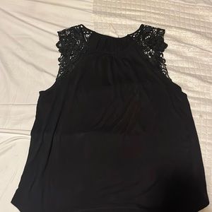 Black tank top with lace type of material on shoulder/sleeve part